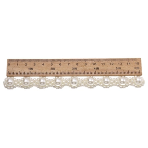 Imitation pearl chain accessory for clogs with measurements on a wooden ruler