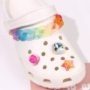 Close-up of matte gradient rainbow chain and colorful jewel charms on white clogs