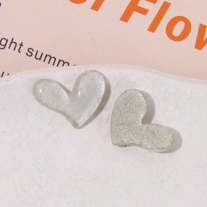 Vista macro di ciondoli a cuore grigio perlato glitter per accessori capelli su vassoio