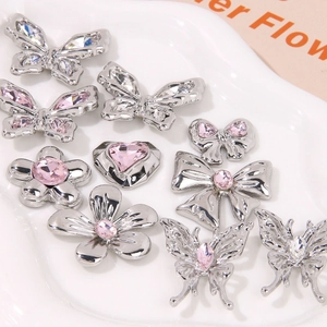 Detail of silver shoe charms with pink rhinestones, butterflies and flowers for clogs