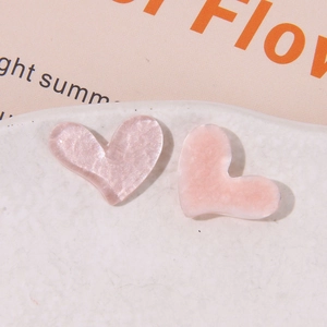 Primo piano di ciondoli a cuore in resina rosa glitterata per accessori per capelli fai-da-te