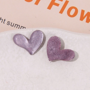 Dettaglio di ciondoli a cuore in resina viola con trama glitterata perlata per decorazioni