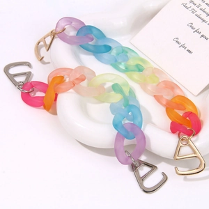 Macro view of gradient rainbow acrylic links with metallic D-ring clasps for shoe decor