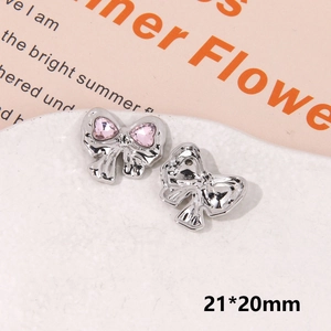 Detailed macro view of a silver bow shoe charm with pink heart crystals, size 21x20mm