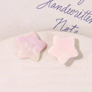 Macro view of gradient glitter star resin charms and solid pink star-shaped DIY accessories