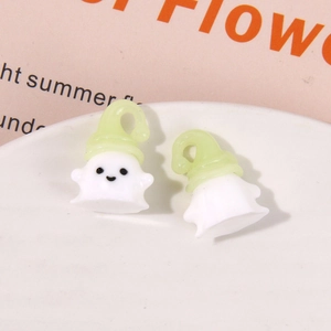 Macro view of white resin ghost charms with green swirl hats for DIY jewelry