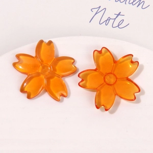 Detail of translucent orange resin cherry blossom charms for DIY jewelry and accessories