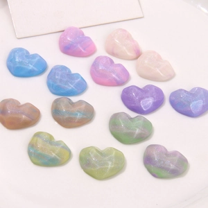 Gros plan de charms cœur en résine avec texture marbrée et finition pailletée macaron