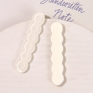 Detalle de accesorios de resina ondulada para pinzas en blanco brillante y blanco leche