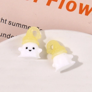 Macro shot of two cute resin Halloween ghost charms with yellow hats for DIY jewelry