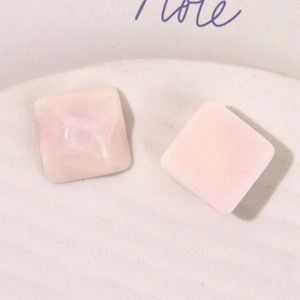 Macro shot of square pink marble resin charms with glitter for DIY jewelry making