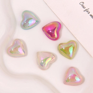 Macro view of colorful pearlescent resin heart charms with aurora finish for DIY crafts