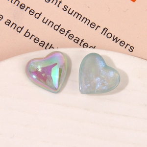 Macro shot of iridescent aurora and glitter resin heart charms for DIY accessories