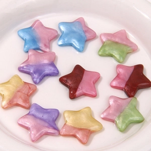 Macro detail of glittery dual-tone resin star charms in a white ceramic dish