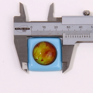 Macro shot of resin geometric earring accessory measuring 30mm with a digital caliper