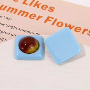 Macro shot of geometric resin earring charms with blue square base and amber inlay