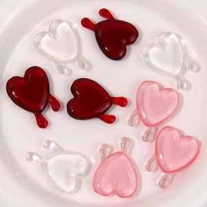 Nahaufnahme von Harzanhängern in Herzform mit Tropfendesign für DIY-Schmuck in Rot und Rosa