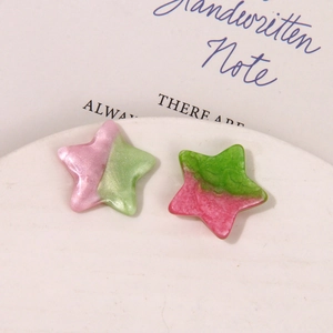 Close-up of glittery gradient star-shaped resin charms for DIY craft making