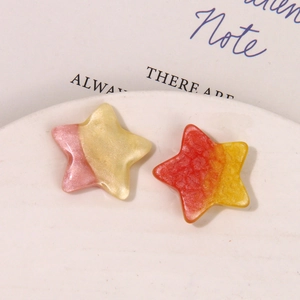 Detailed macro view of gradient glitter star resin charms for DIY earring accessories