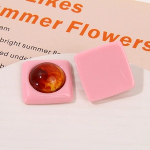 Detailed macro view of pink resin square earrings with amber marble circular inlays