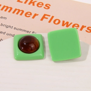 Detail showing green square resin earring studs with amber texture inlay and smooth finish