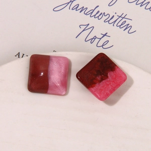 Close-up of bicolor resin square tiles with pearlescent starry glitter for DIY jewelry