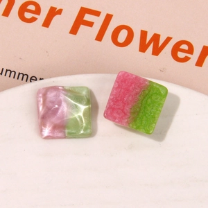 Macro shot of square resin earring charms with pink and green pearlescent water ripple textures