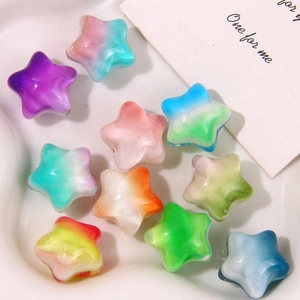 Vista macro de dijes de estrellas 3D en degradado para joyería DIY en bandeja cerámica
