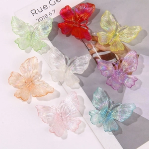 Macro detail of iridescent acrylic butterfly charms with shimmering pearlescent coating