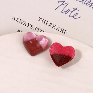 Macro shot of gradient heart resin charms with starry sand and cracked texture effects
