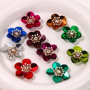 Macro detail of colorful metallic sequin flower charms with rhinestones for DIY accessories