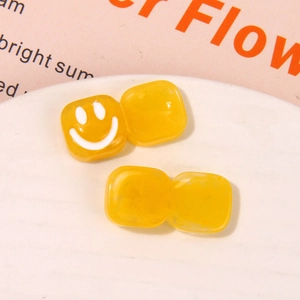 Detail of yellow resin square smiley face charms for DIY earrings and hair accessories
