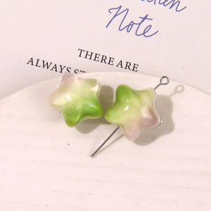 Detalle de dijes de estrella degradados verde y rosa con alto brillo en un plato