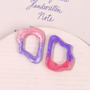 Detailed view of translucent wavy gradient resin charms with glitter for DIY jewelry making