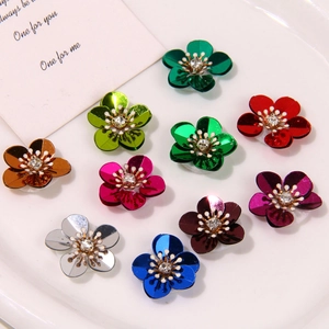 Macro detail of multi-colored metallic flower charms with sparkling center rhinestones