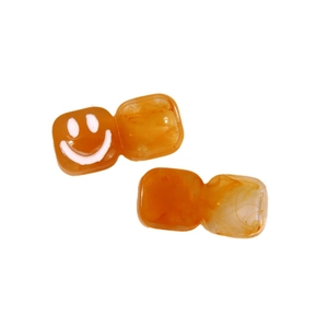 Amber resin earrings featuring square charms and a white smiley face design on orange base