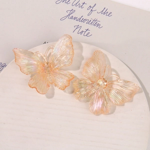 Close-up of iridescent acrylic butterfly jewelry pieces with delicate pearlescent texture