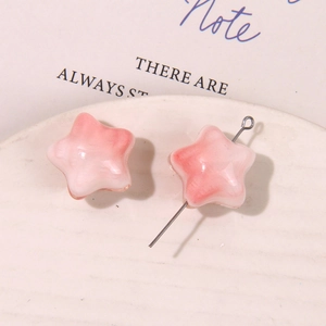 Detalle de cuentas de estrella de cerámica con degradado rosa para bisutería DIY