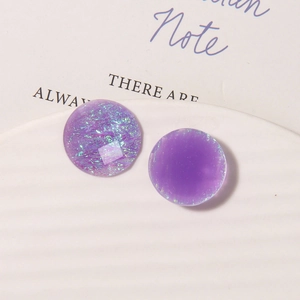 Macro detail of geometric purple resin earring cabochons with iridescent starry glitter