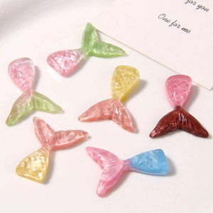 Macro view of glittering resin mermaid tail charms for DIY crafts and shoe decoration