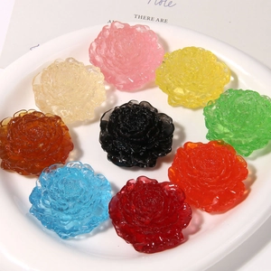 Flat lay of colorful 3D translucent resin daisy flowers arranged on white porcelain plate