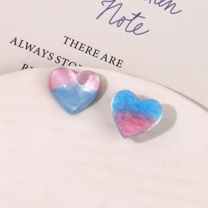 Clous d'oreilles cœur en résine avec dégradé rose-bleu et fini perlé
