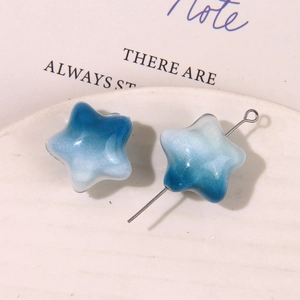 Detalle macro de dije de estrella en degradado azul con pin plateado para joyería DIY