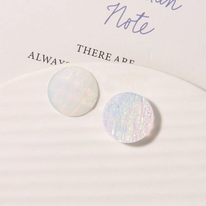 Macro detail of round resin earring charms with iridescent starry sky oil painting texture
