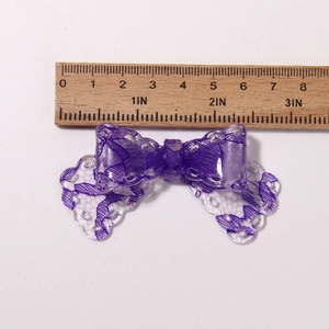 Violetter Harz-Blumenbogen mit Spitzenmuster neben einem Lineal zur Größenmessung