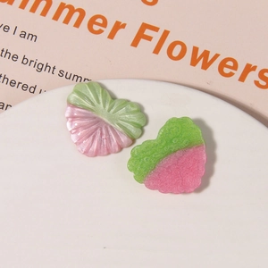 Detail of pink and green resin heart charms with radial textures for DIY jewelry making