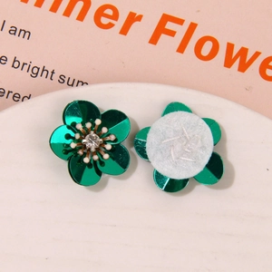Detailed view of green petal flower accessories with rhinestones and white felt backing