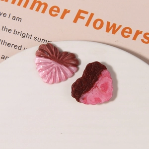 Macro detail of heart-shaped glitter resin charms with pleated and frosted textures
