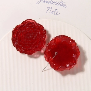Macro view of 3D red resin rose beads with metal eyelets for DIY jewelry making