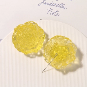 Macro detail of yellow resin rose pendants with translucent finish on a white plate